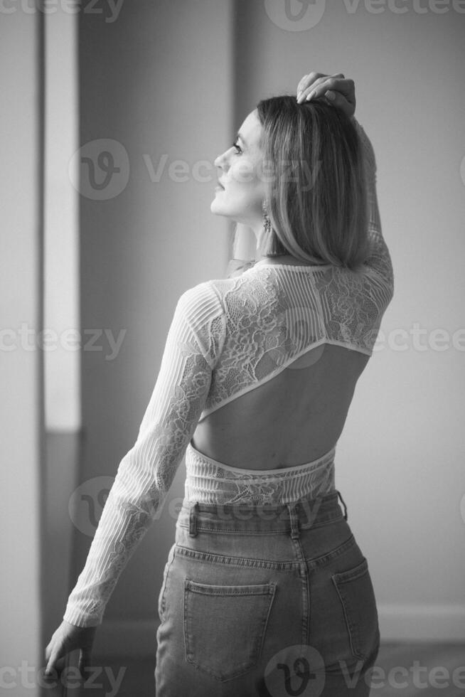 Sexy young woman. Girl posing on wall in studio. photo