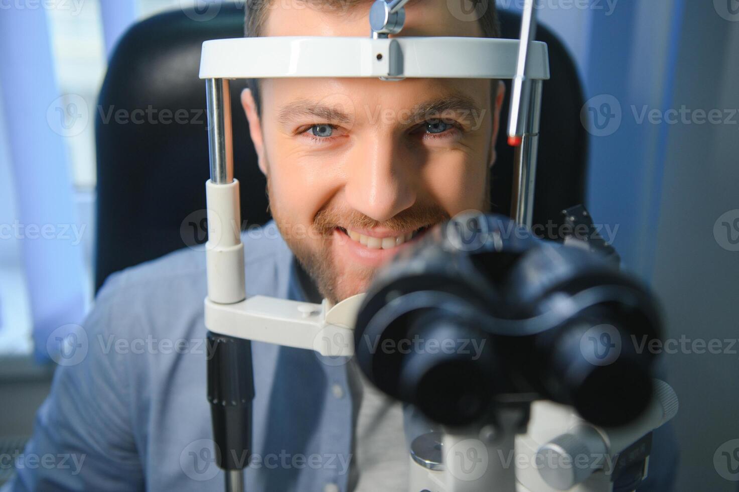 Handsome young man is checking the eye vision in modern ophthalmology clinic. Patient in ophthalmology clinic photo