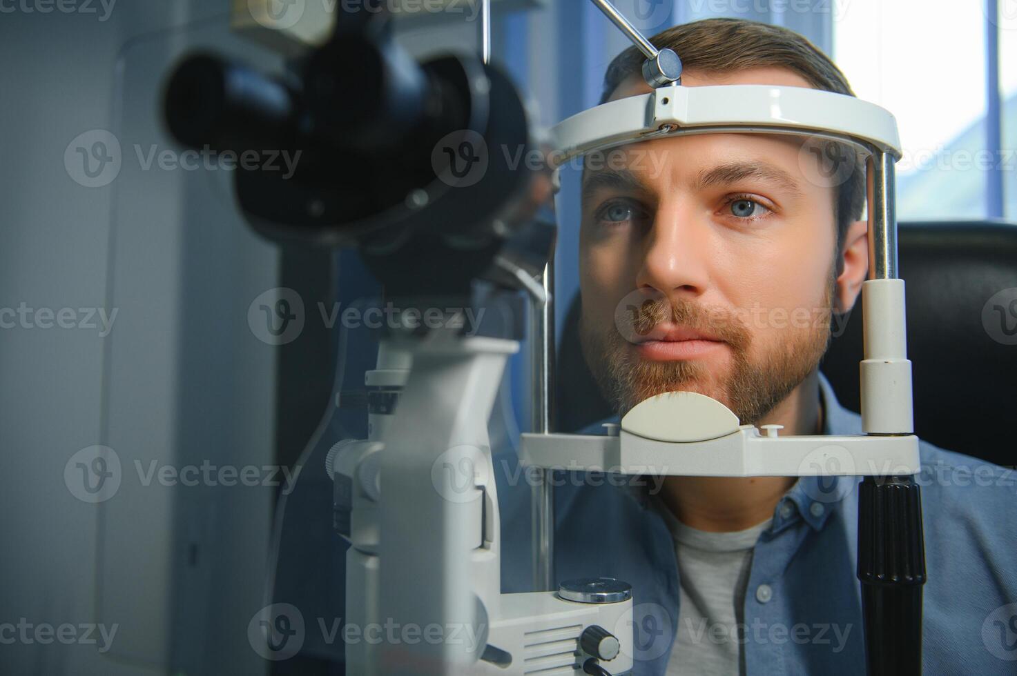 Adult man eyesight test with binocular slit-lamp. Checking retina of a male eye close-up. Ophthalmology Clinic photo