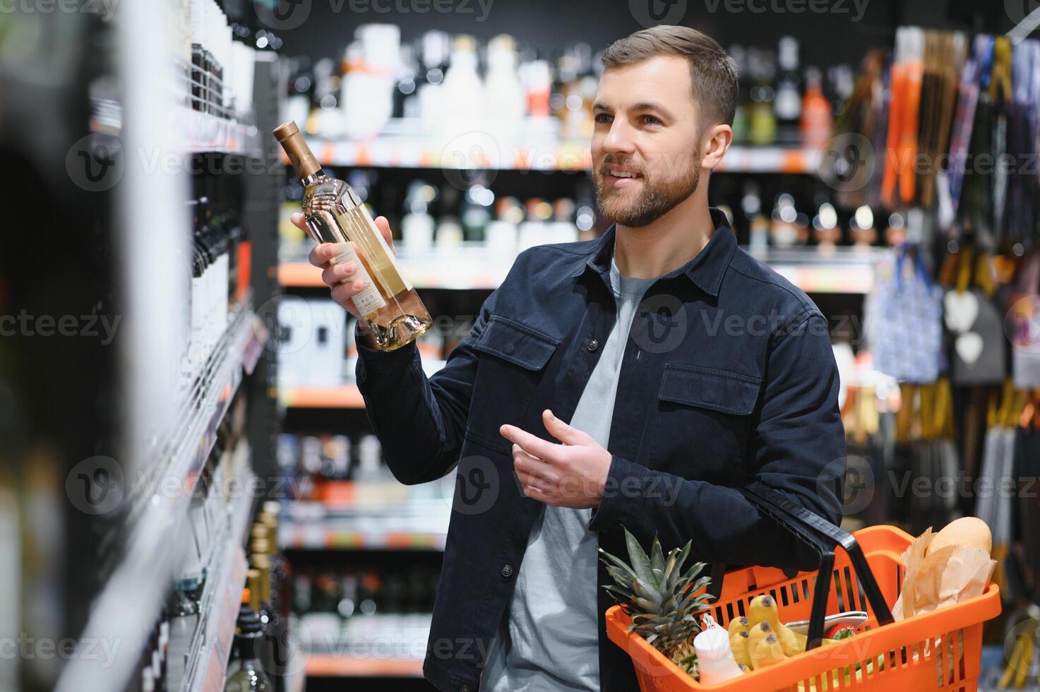 Young man buying groceries at the supermarket. Other customers in background. Consumerism concept. photo