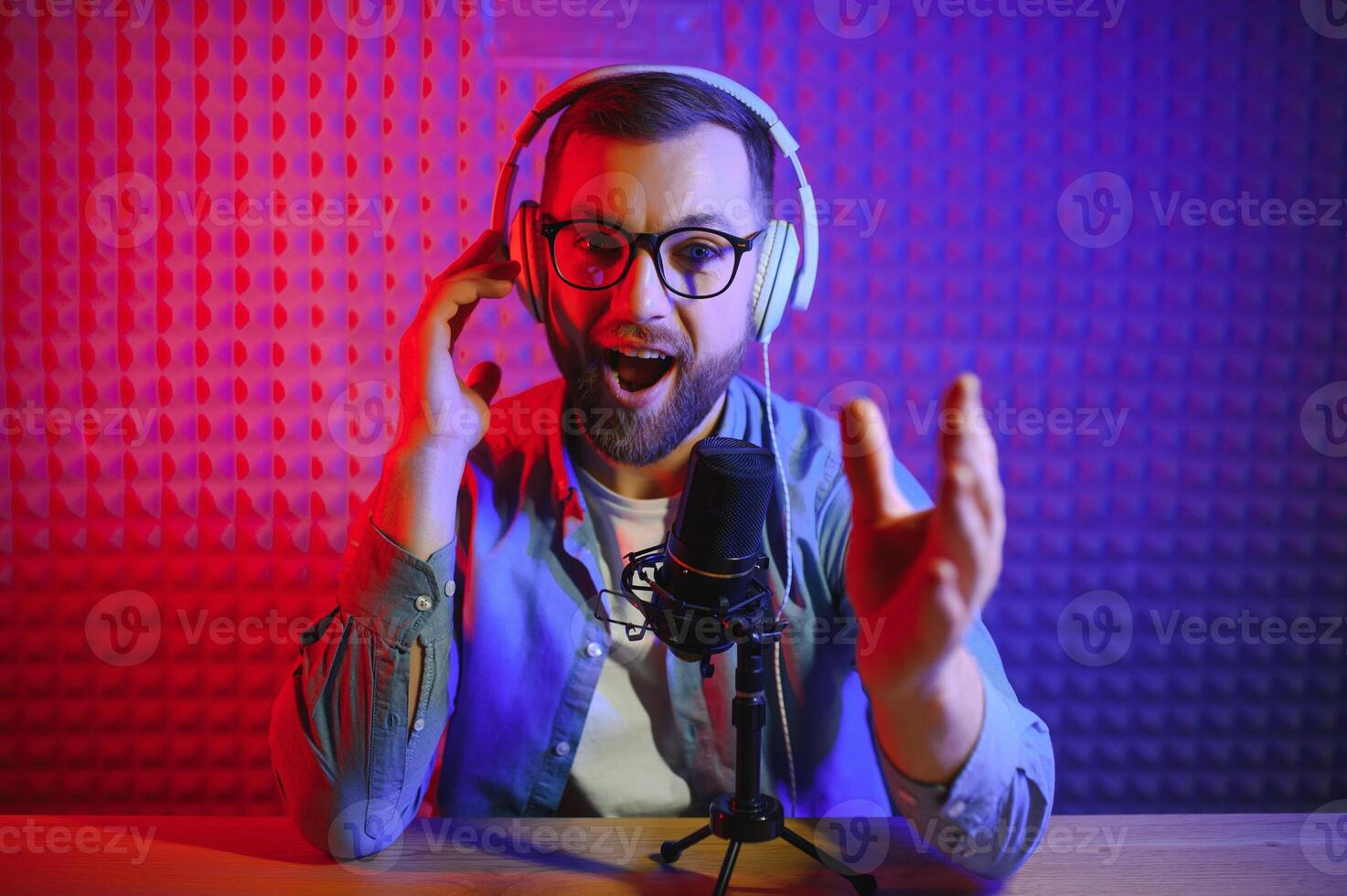 A blogger records content in his studio. The host of the blog is a young man who is very enthusiastic about telling his subscribers a story. photo