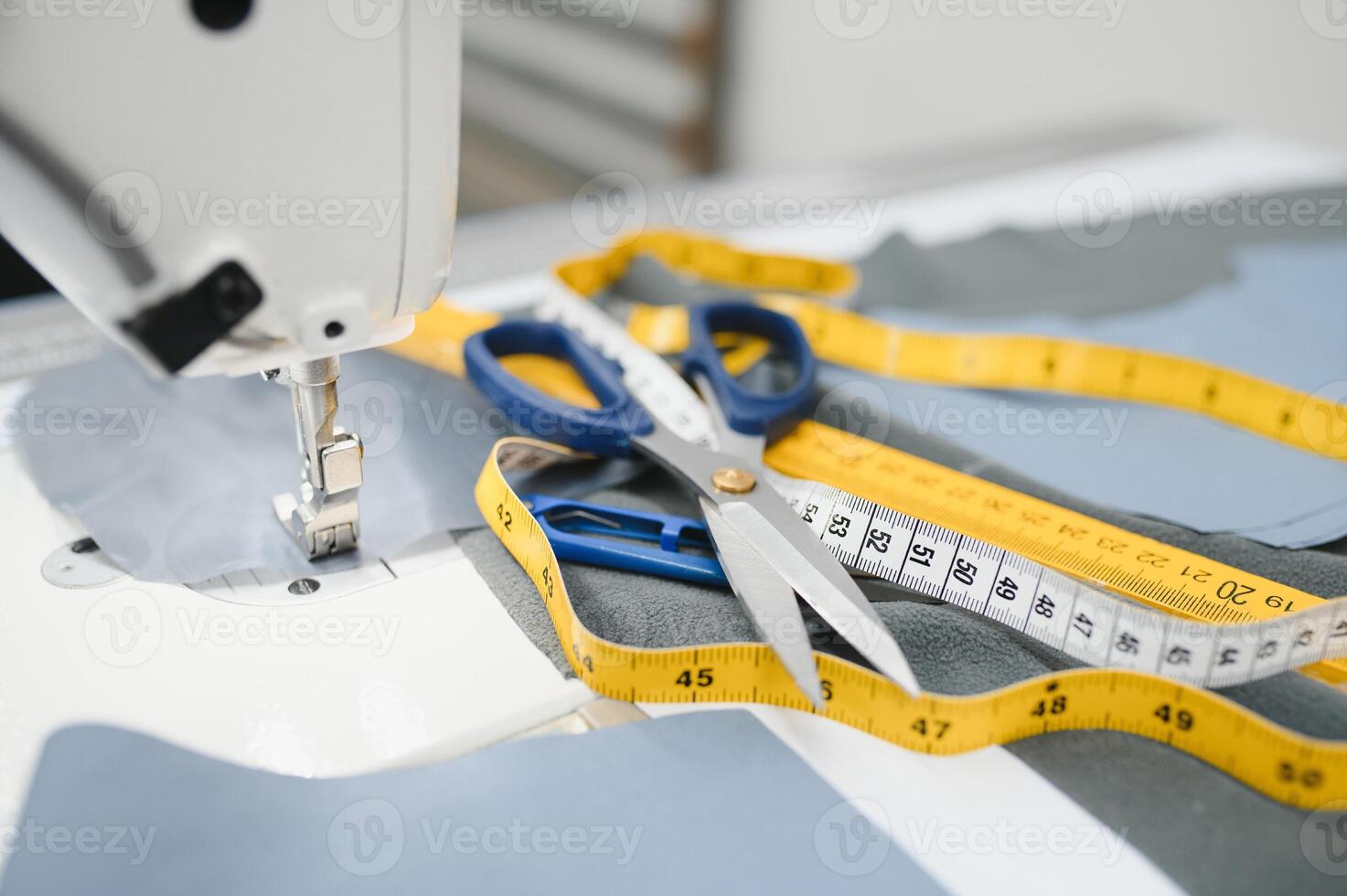 Composition of sewing thread, scissors and tape measure on a white table. Concept of a clothing designer photo