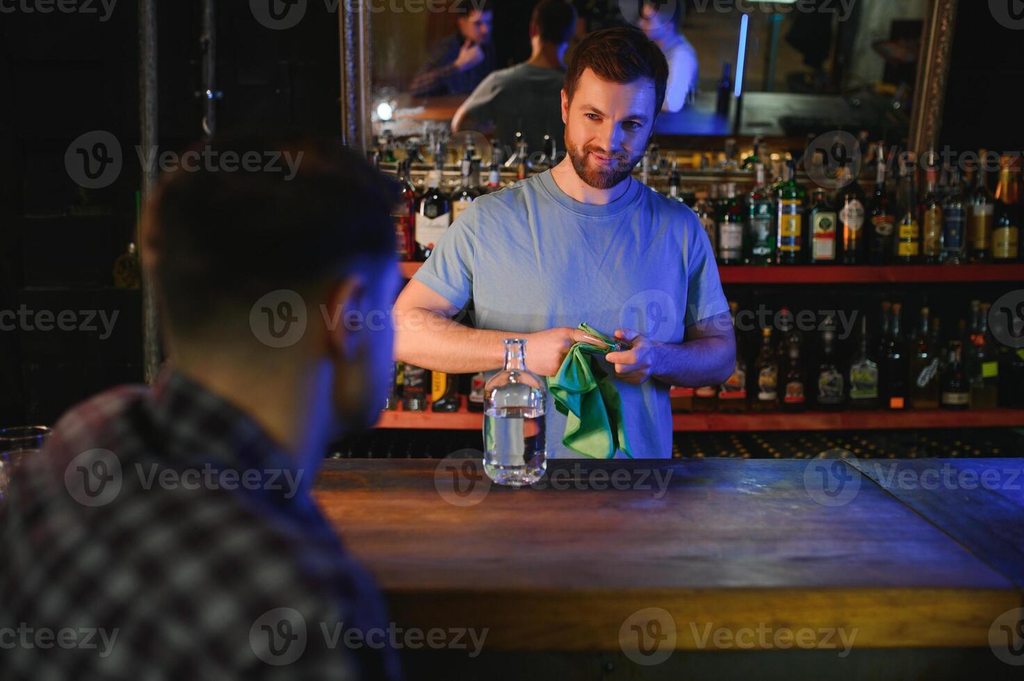Portrait Of Smiling Male Bar Owner Standing Behind Counter photo
