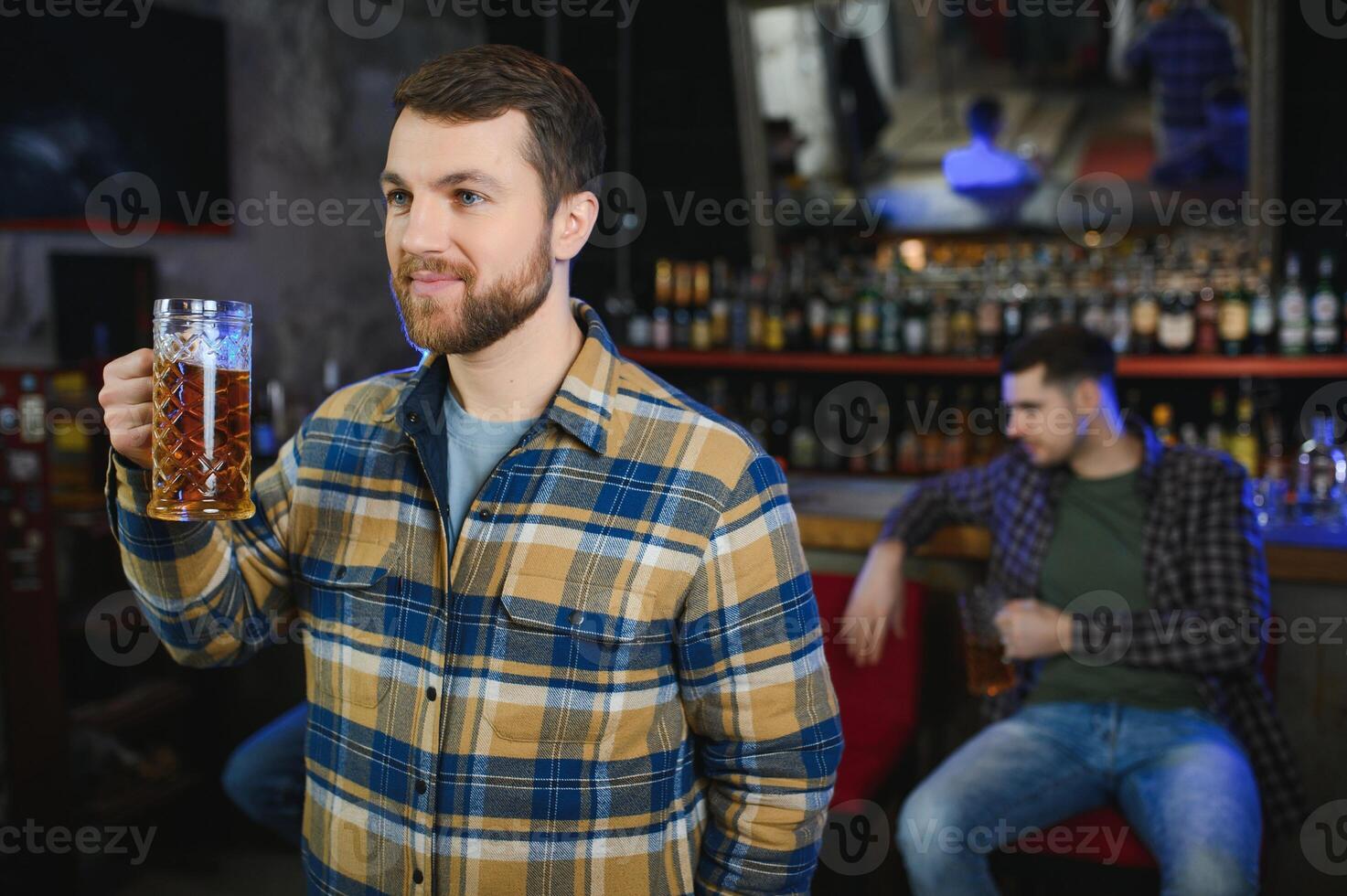 Tasting a good beer. Portrait of thoughtful men drinking beer at the bar photo