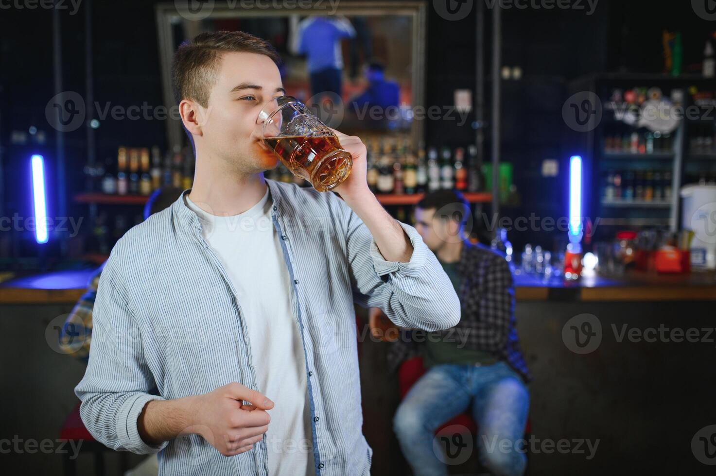 Tasting a good beer. Portrait of thoughtful men drinking beer at the bar photo
