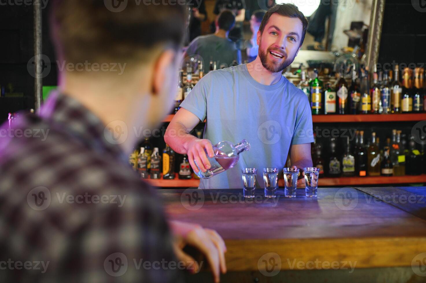 Handsome bar tender standing behind his counter in a pub photo