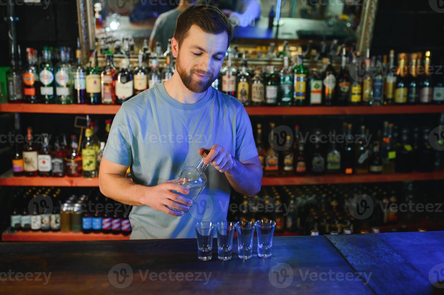 Handsome bar tender standing behind his counter in a pub photo