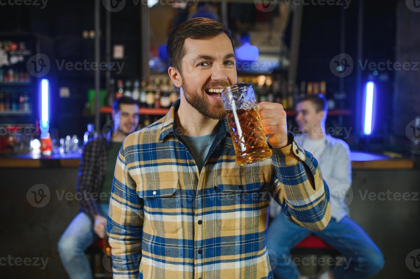 Tasting a good beer. Portrait of thoughtful men drinking beer at the bar photo