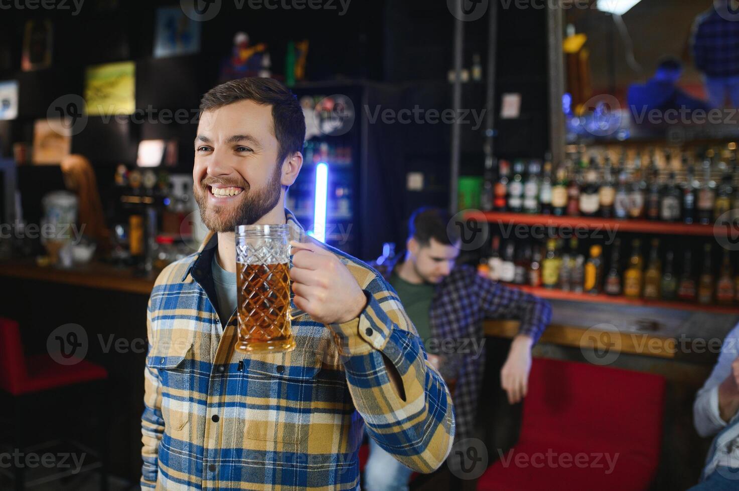 Night in bar. Portrait of cheerful men drinking beer at the bar photo