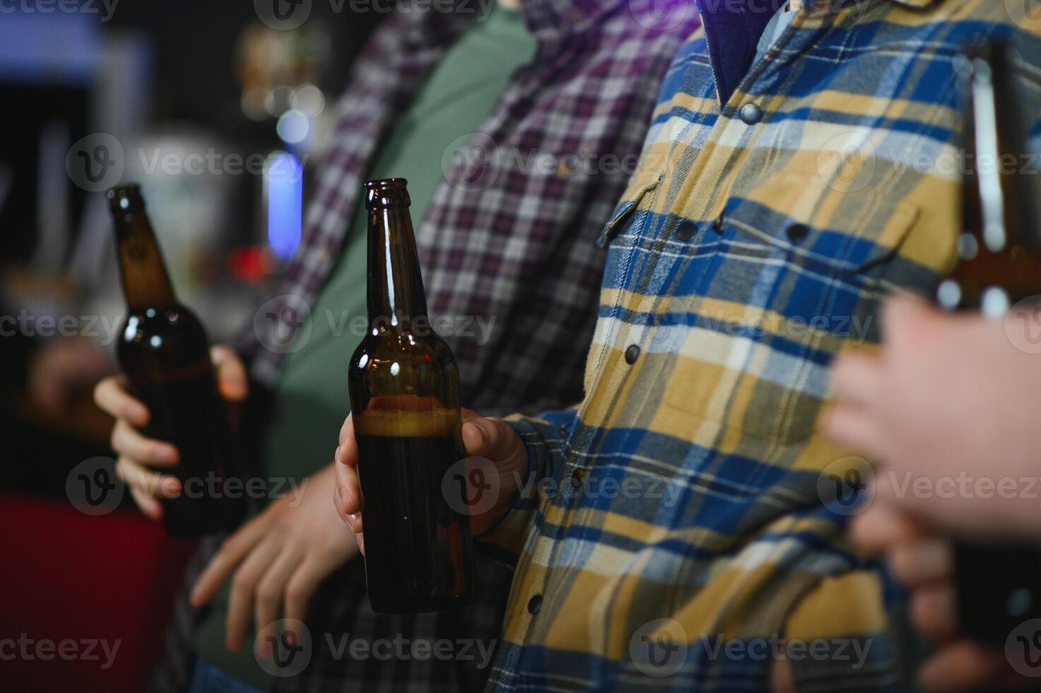 Friends having fun. Happy young men in casual wear drinking beer in pub. photo