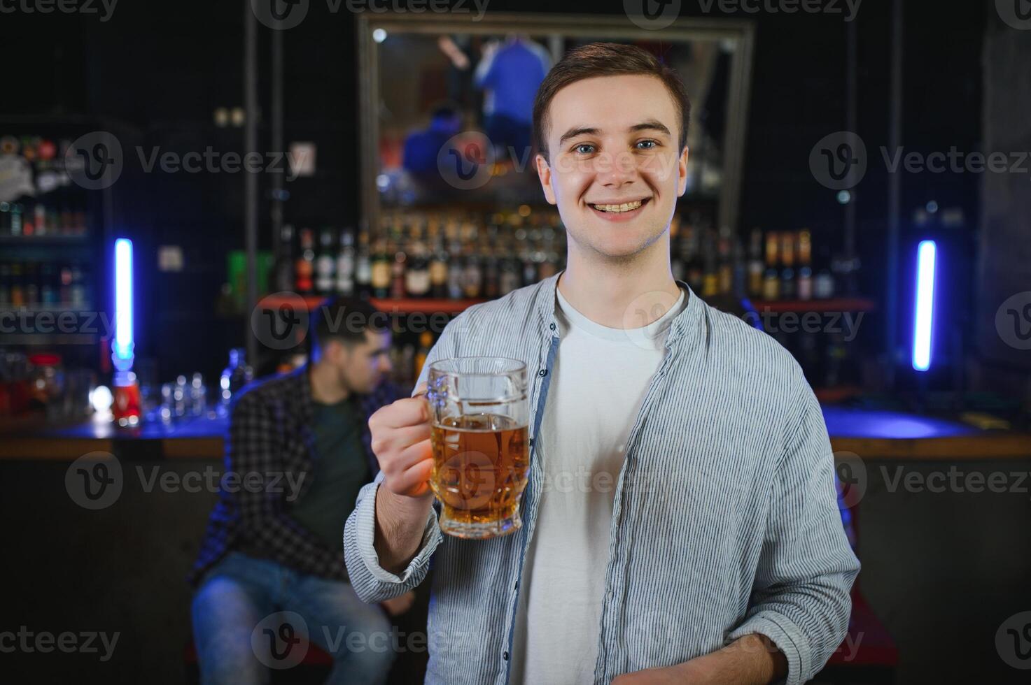 Handsome bearded man drinking beer at the bar counter in pub photo