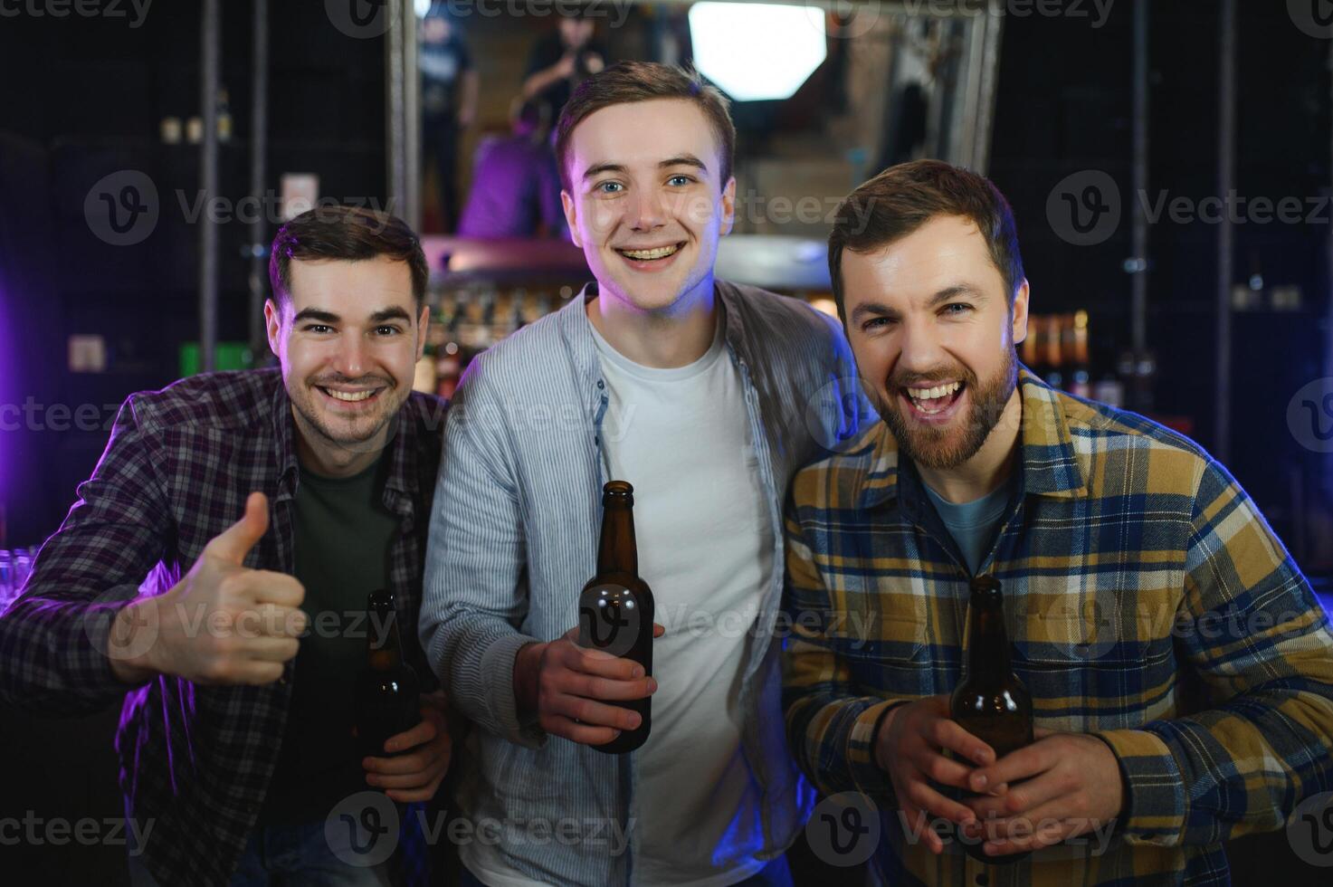 Friends resting in the pub with beer in hands. Having conversation. photo