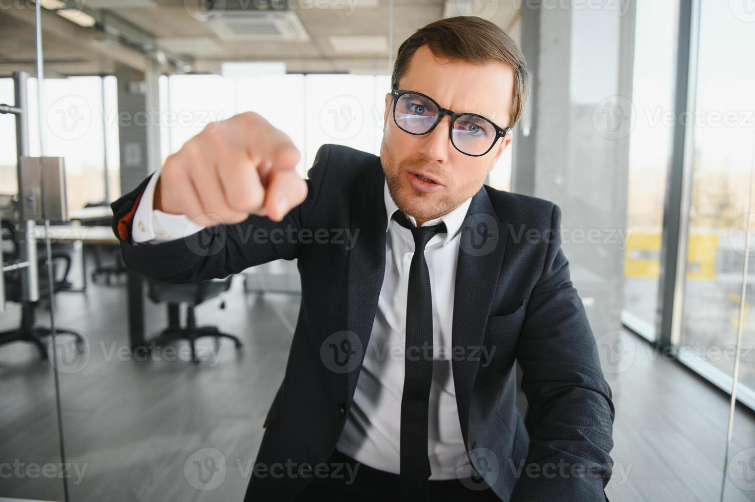 Angry senior businessman sitting at his desk and screaming photo