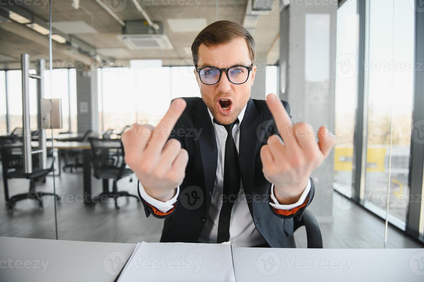 Portrait of angry business man showing double middle fingers photo