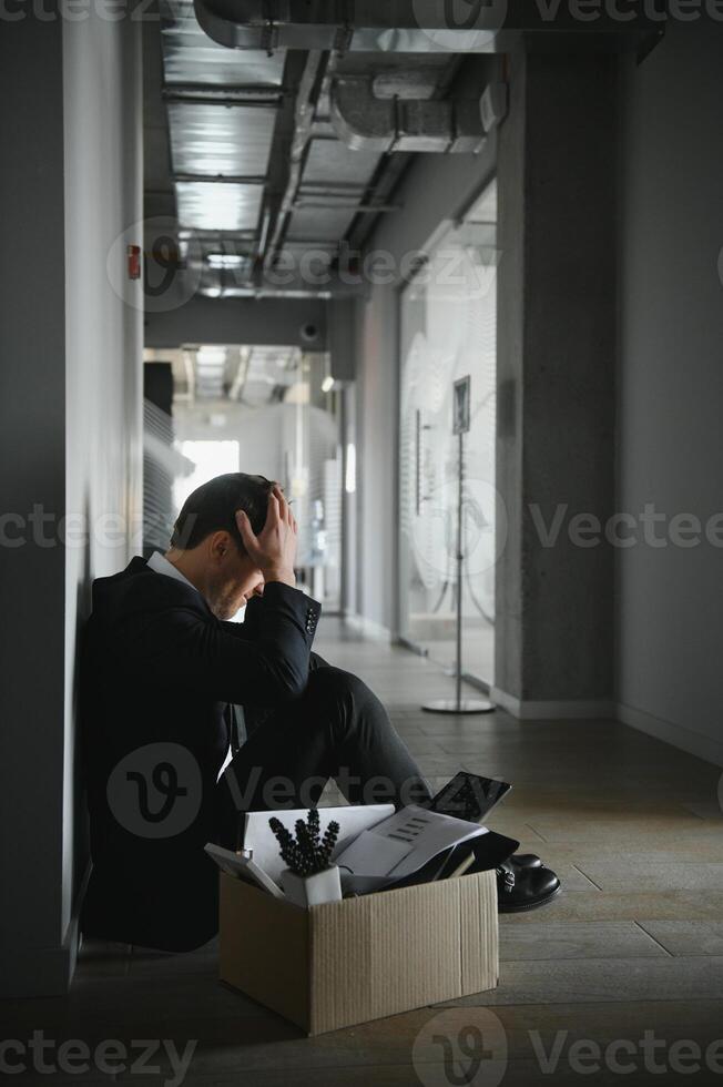business, firing and job loss concept - fired male office worker with box of his personal stuff. photo