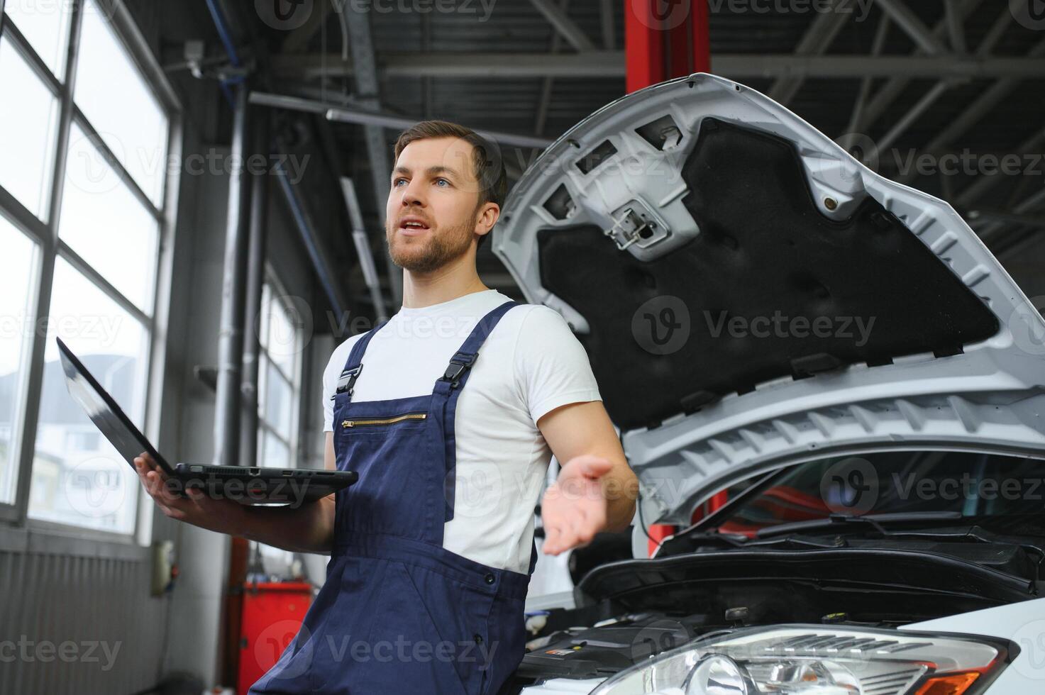 Auto service, repair, maintenance concept. mechanic checks the car, making diagnostics with laptop at the service station. Service maintenance of industrial to engine repair. photo