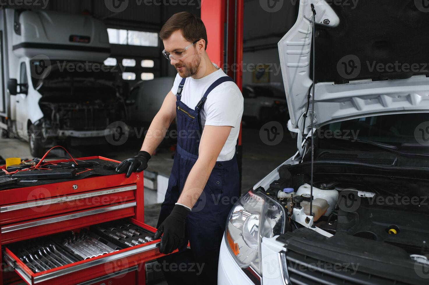 Portrait Shot of a Handsome Mechanic Working on a Vehicle in a Car Service. Modern Clean Workshop. photo