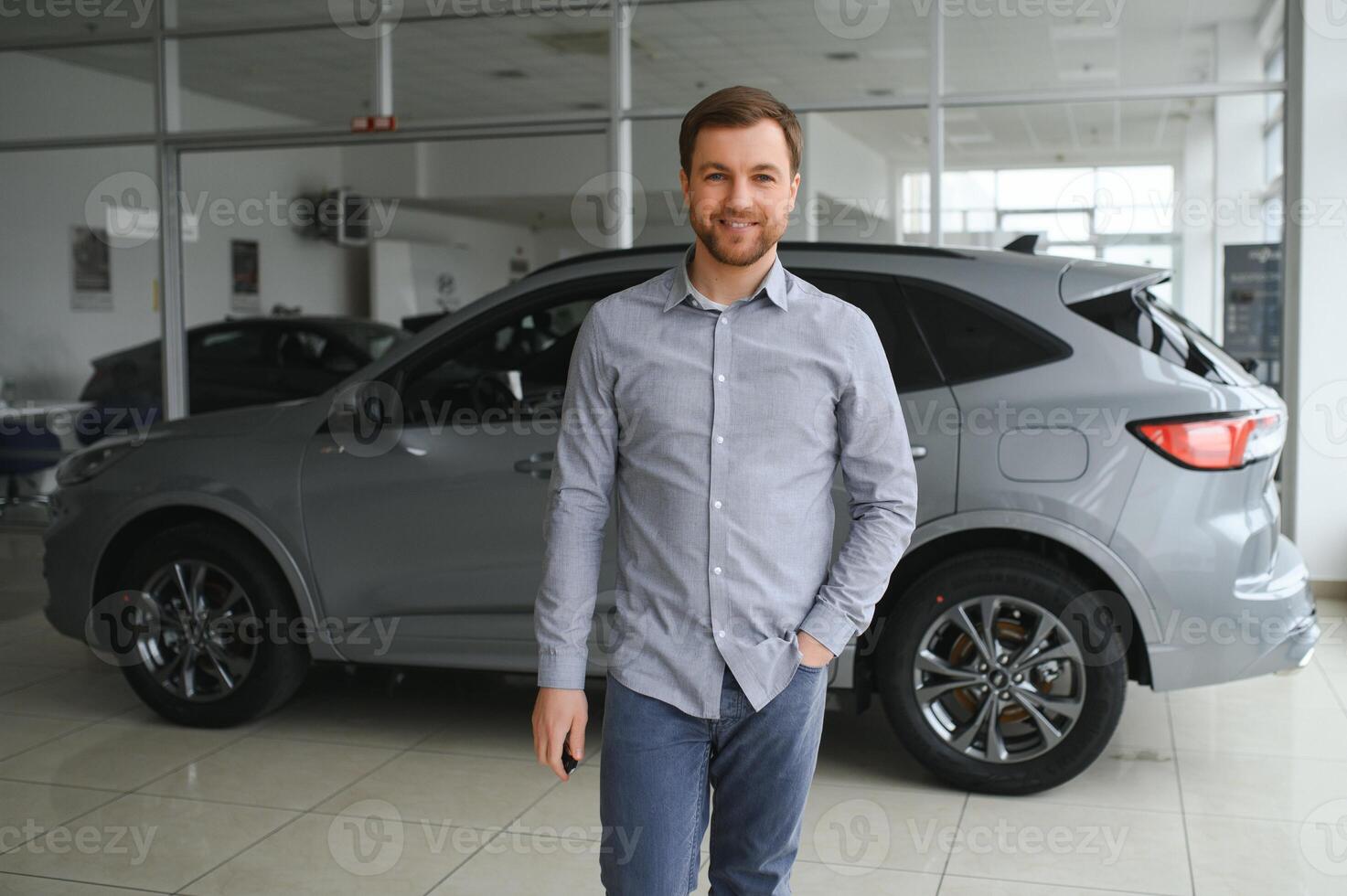 a man chooses a new car for himself walks between the rows in a car dealership photo