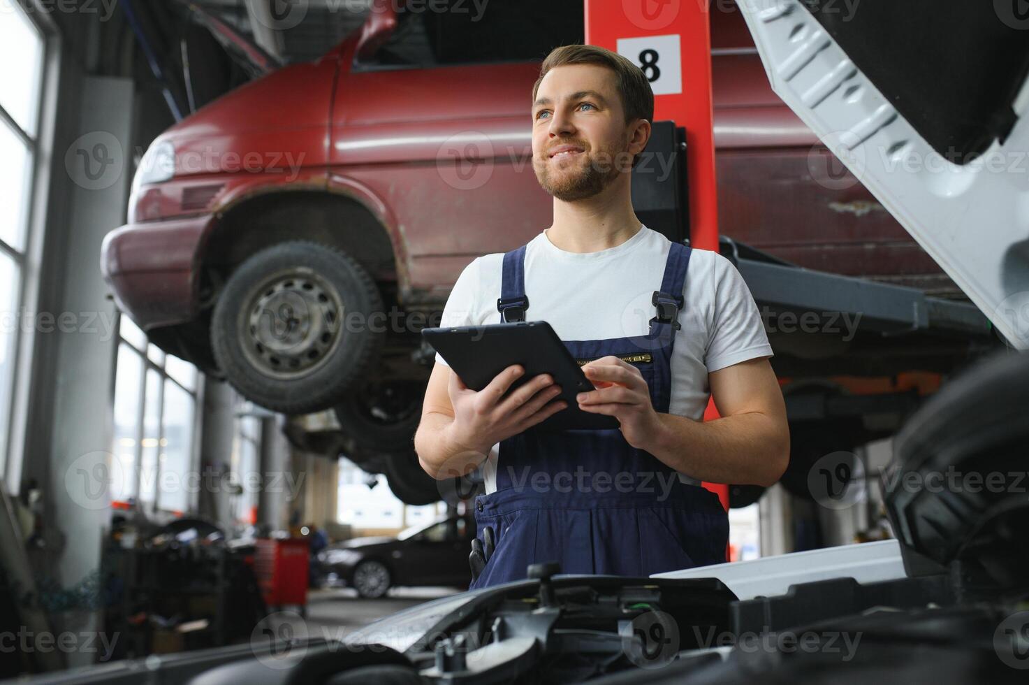 Automobile computer diagnosis. Car mechanic repairer looks for engine failure on diagnostics equipment in vehicle service workshop photo