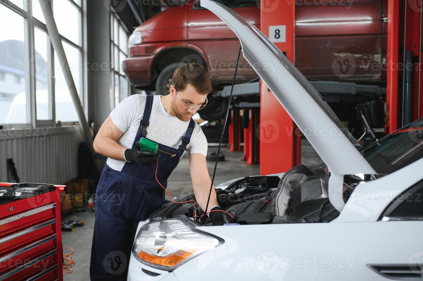 Auto mechanic working on car engine in mechanics garage. Repair service. photo