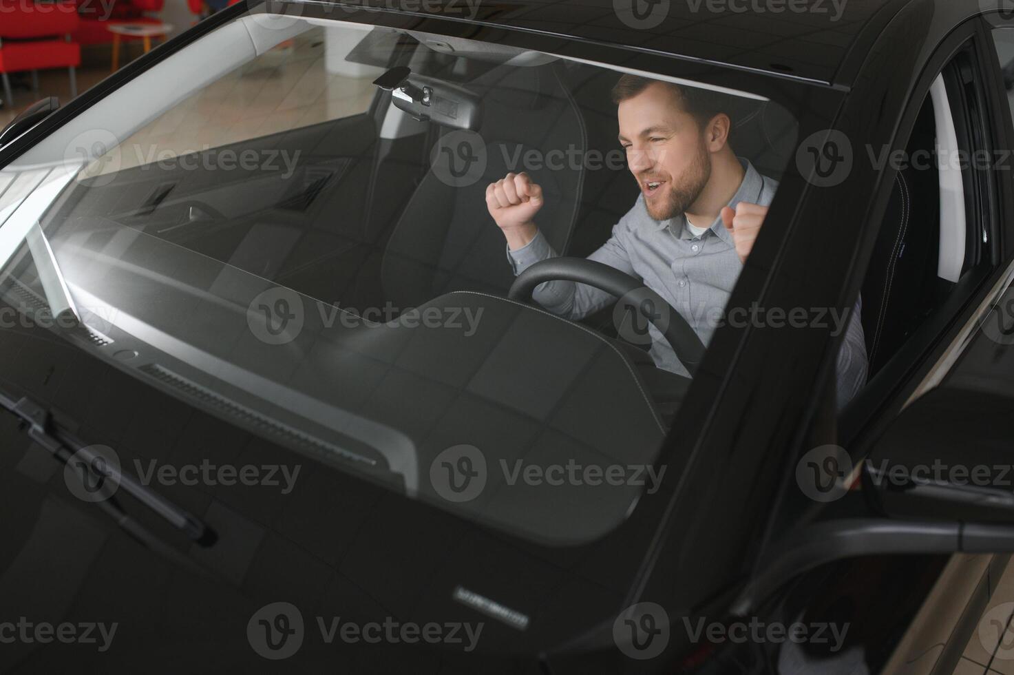 Successful and happy. Shot of a happy mature man smiling to the camera sitting in his brand new car at the local dealership photo