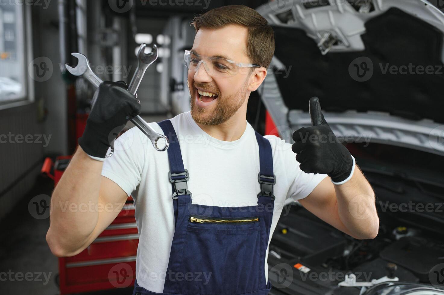 Portrait of a smiling fixing a car engine in his garage photo
