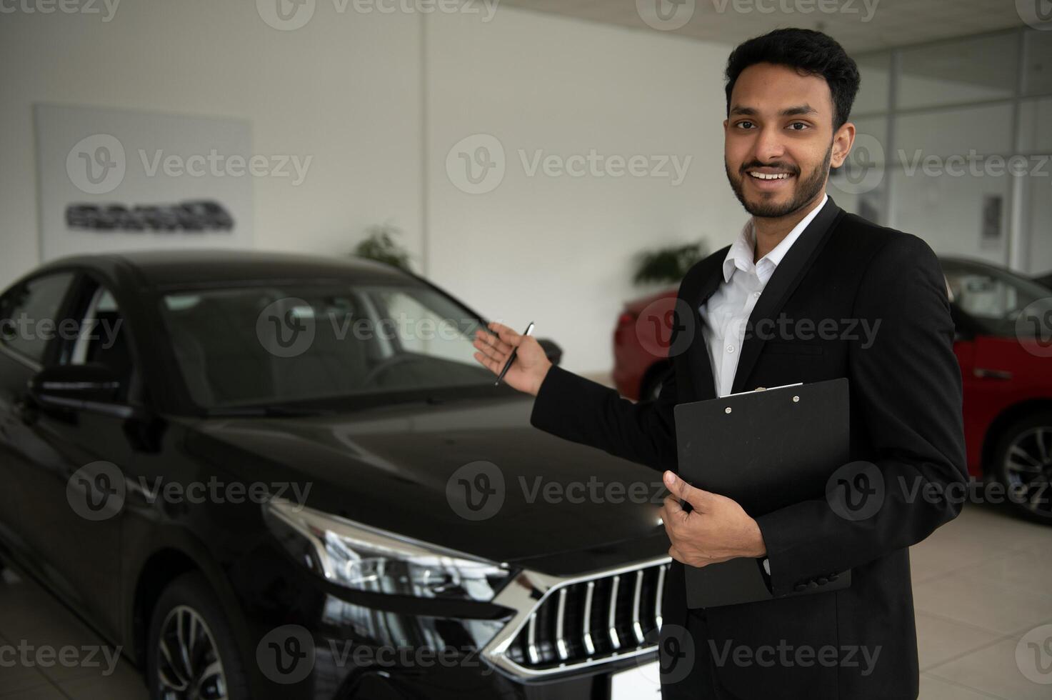 indian cheerful car salesman at showroom. photo