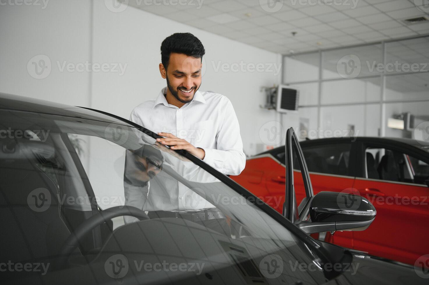happy indian man buy new biodiesel eco automobile in lux showroom. photo