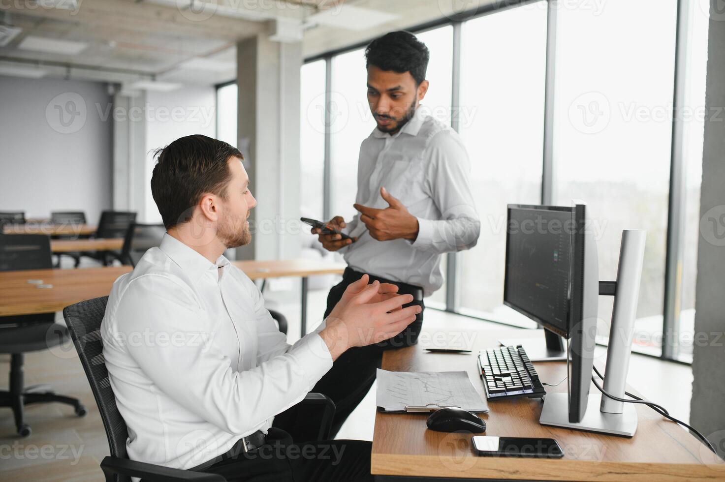 Two men traders sitting at desk at office together monitoring stocks data candle charts on screen analyzing price flow smiling cheerful having profit teamwork concept photo