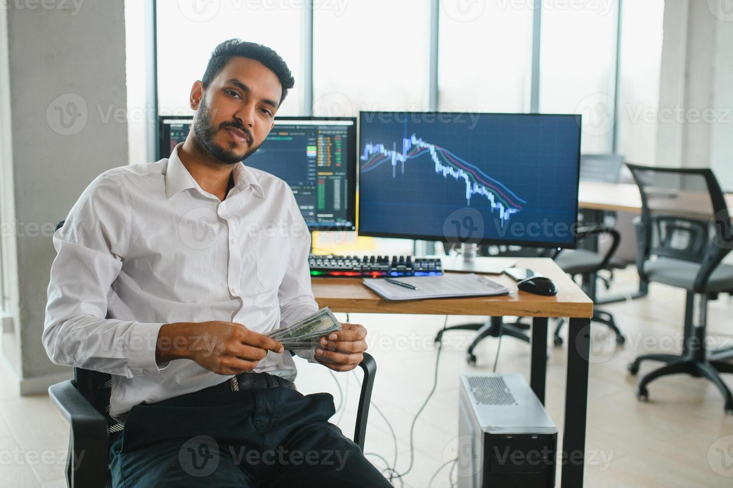 Thoughtful concentrated indian business man entrepreneur investor manager using computer, watching webinar working in office analyzing online data market thinking doing web research looking at laptop. photo