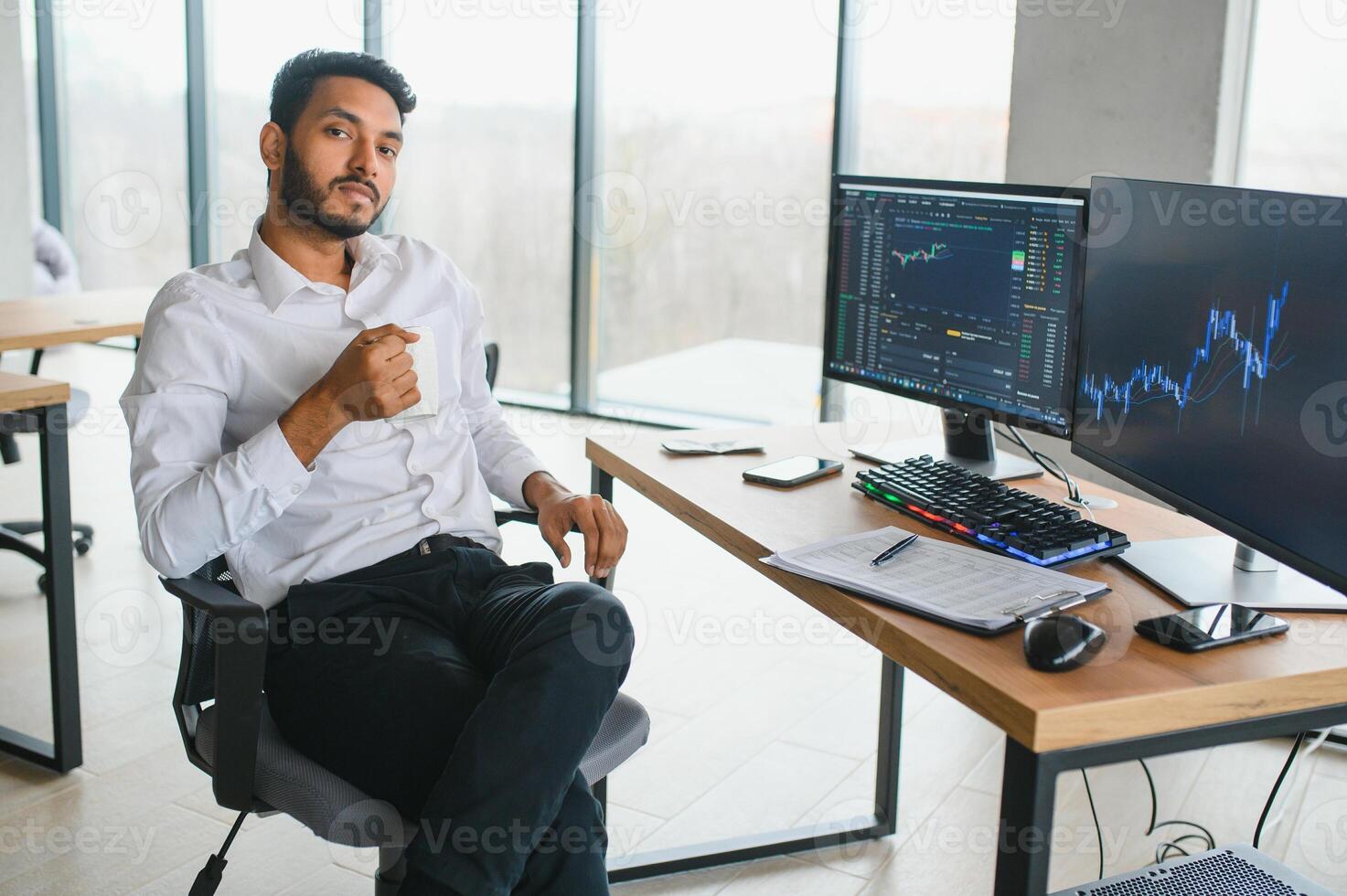 Portrait of a positive successful Indian or Arabian trader, stock market broker, Crypto charts on laptop screen photo
