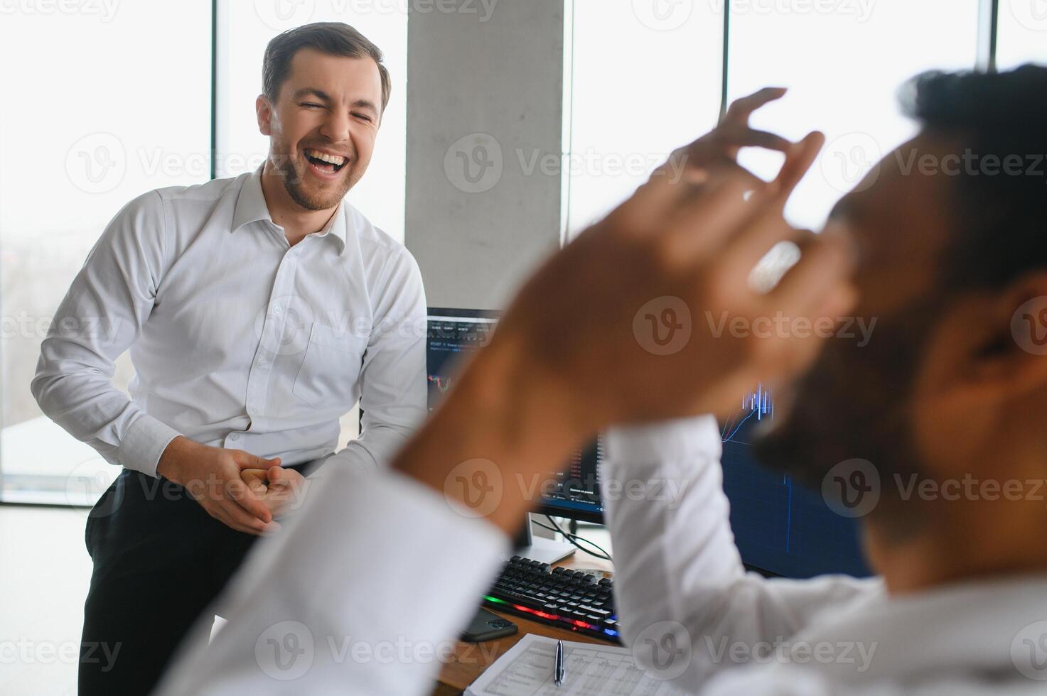 Two successful trader sitting in office and looking at screen, checking cryptocurrency information data on finance market graph, pointing on monitor photo