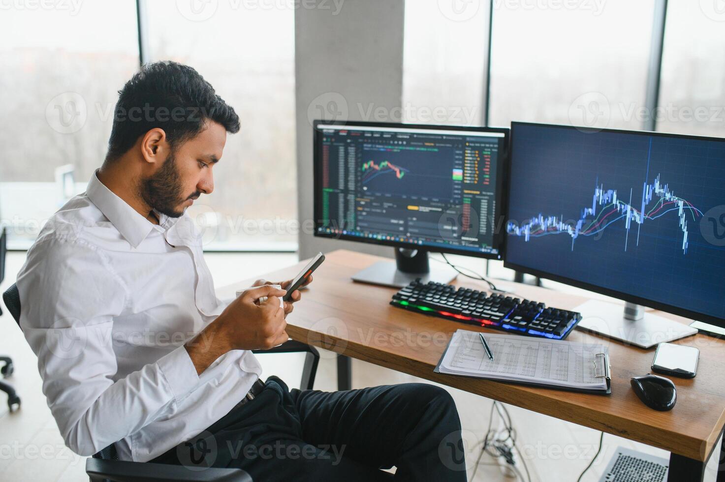 Thoughtful concentrated indian business man entrepreneur investor manager using computer, watching webinar working in office analyzing online data market thinking doing web research looking at laptop. photo