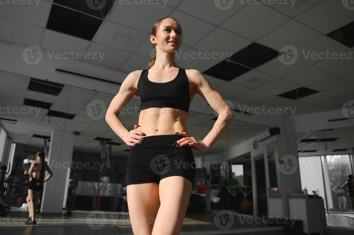Image of a beautiful strong happy cheerful young sports woman posing at gym photo