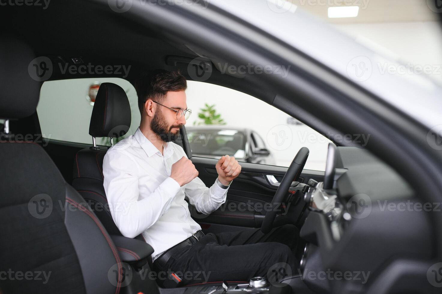 a man examines a car in a car dealership photo