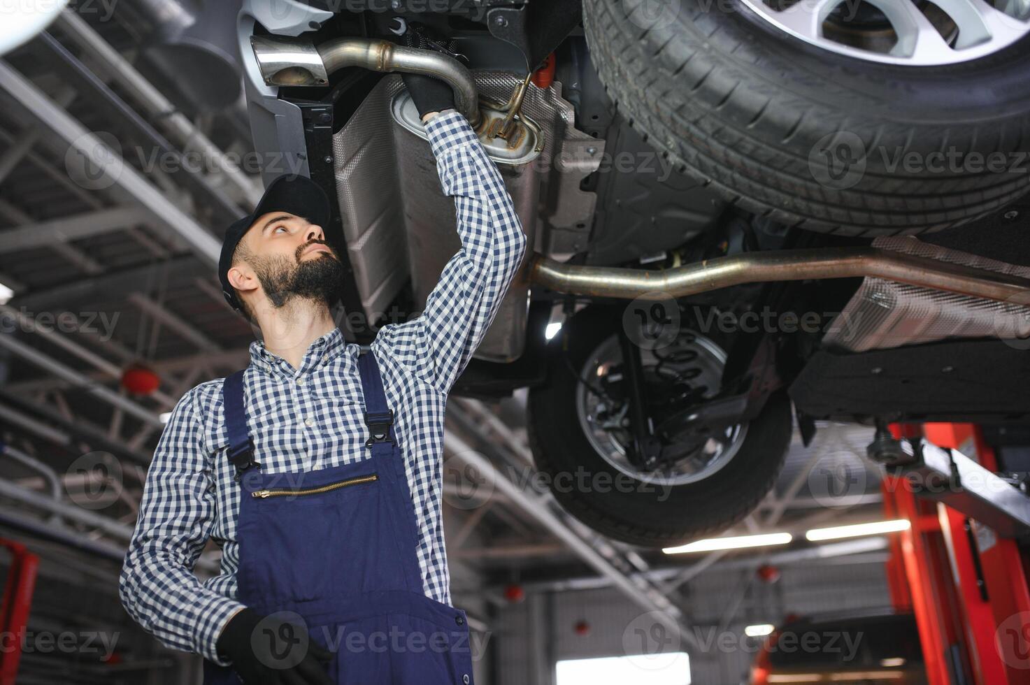 Adult man in blue colored uniform works in the automobile salon. photo