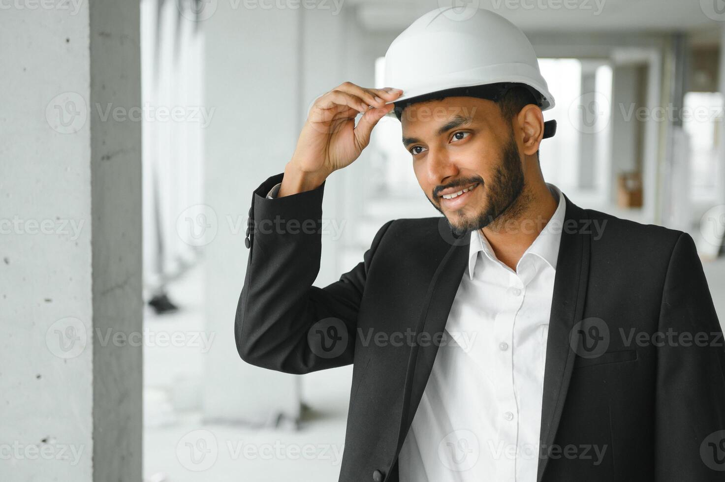 Asian engineer handsome man or architect with white safety helmet in construction site. Standing at modern building construction. Worker asian man working project building photo
