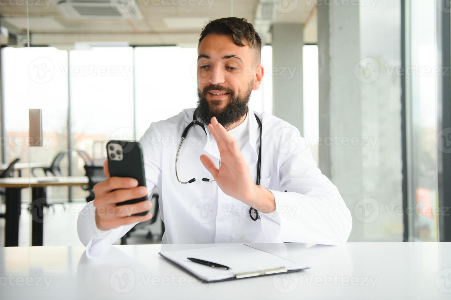 Cheerful young arab man doctor having call with patient photo