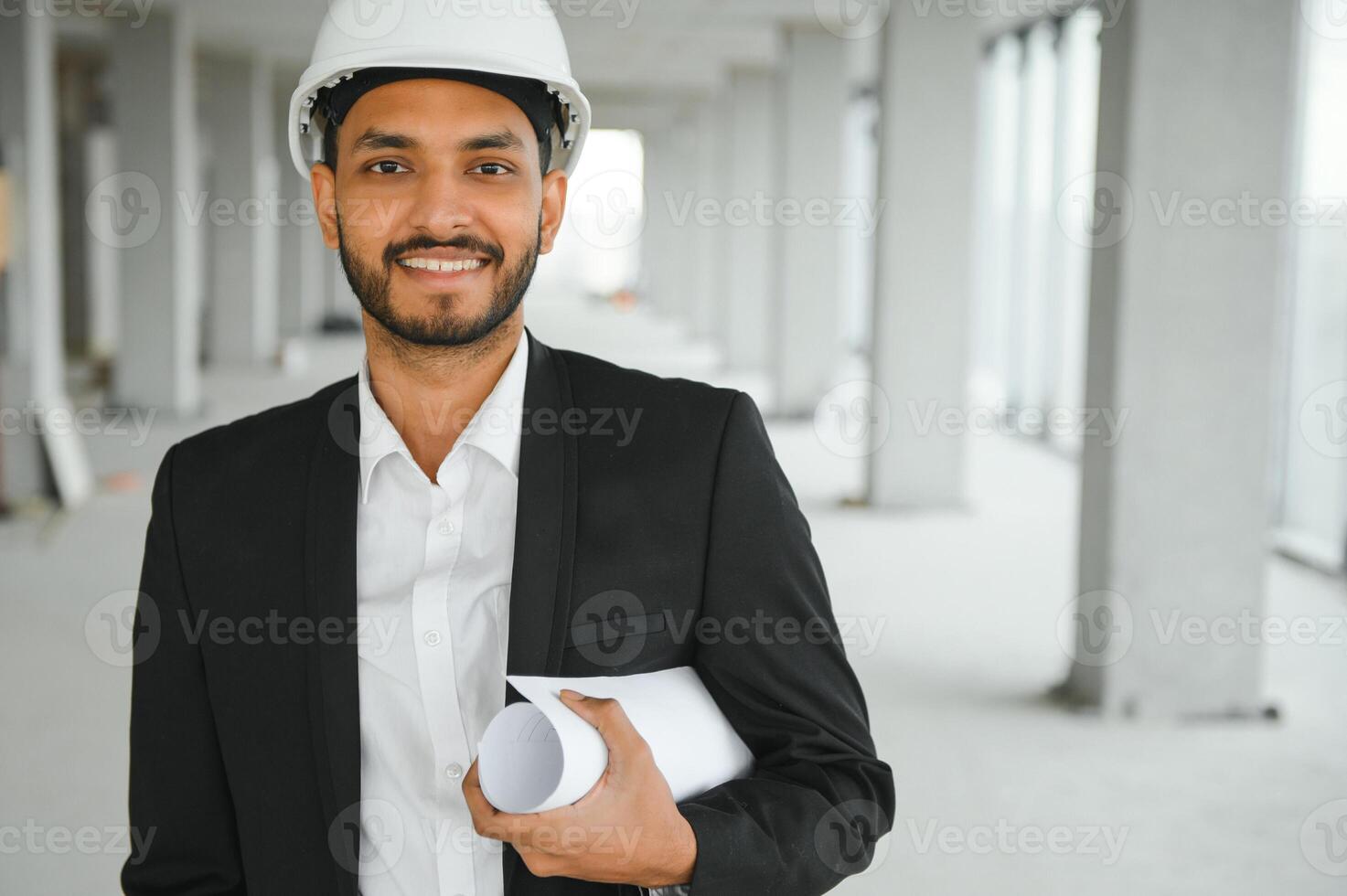 Asian engineer handsome man or architect with white safety helmet in construction site. Standing at modern building construction. Worker asian man working project building photo