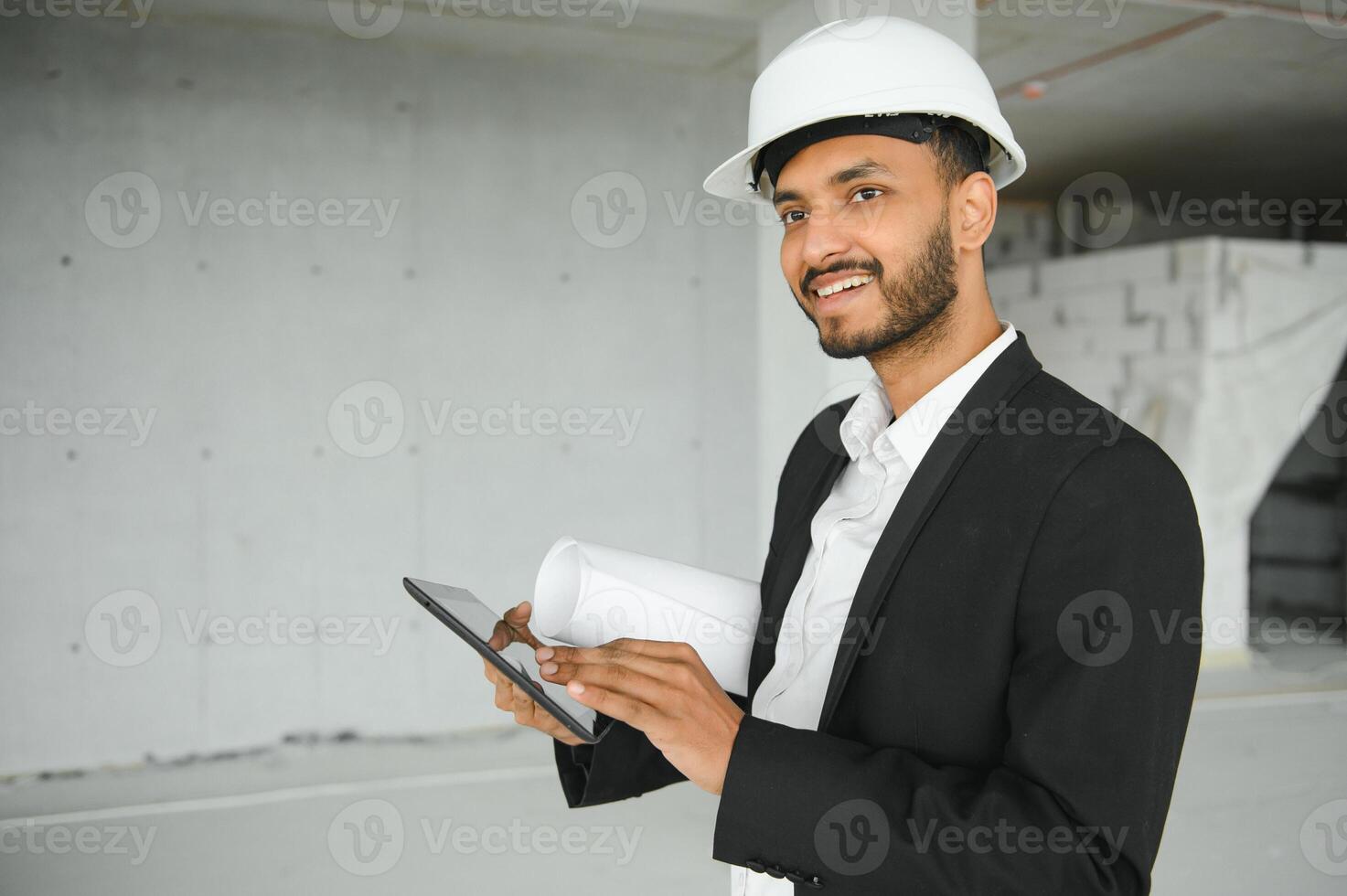 Confident asian engineer man Using tablet for checking and maintenance to inspection at modern home building construction. Architect working with white safety helmet in construction site. photo