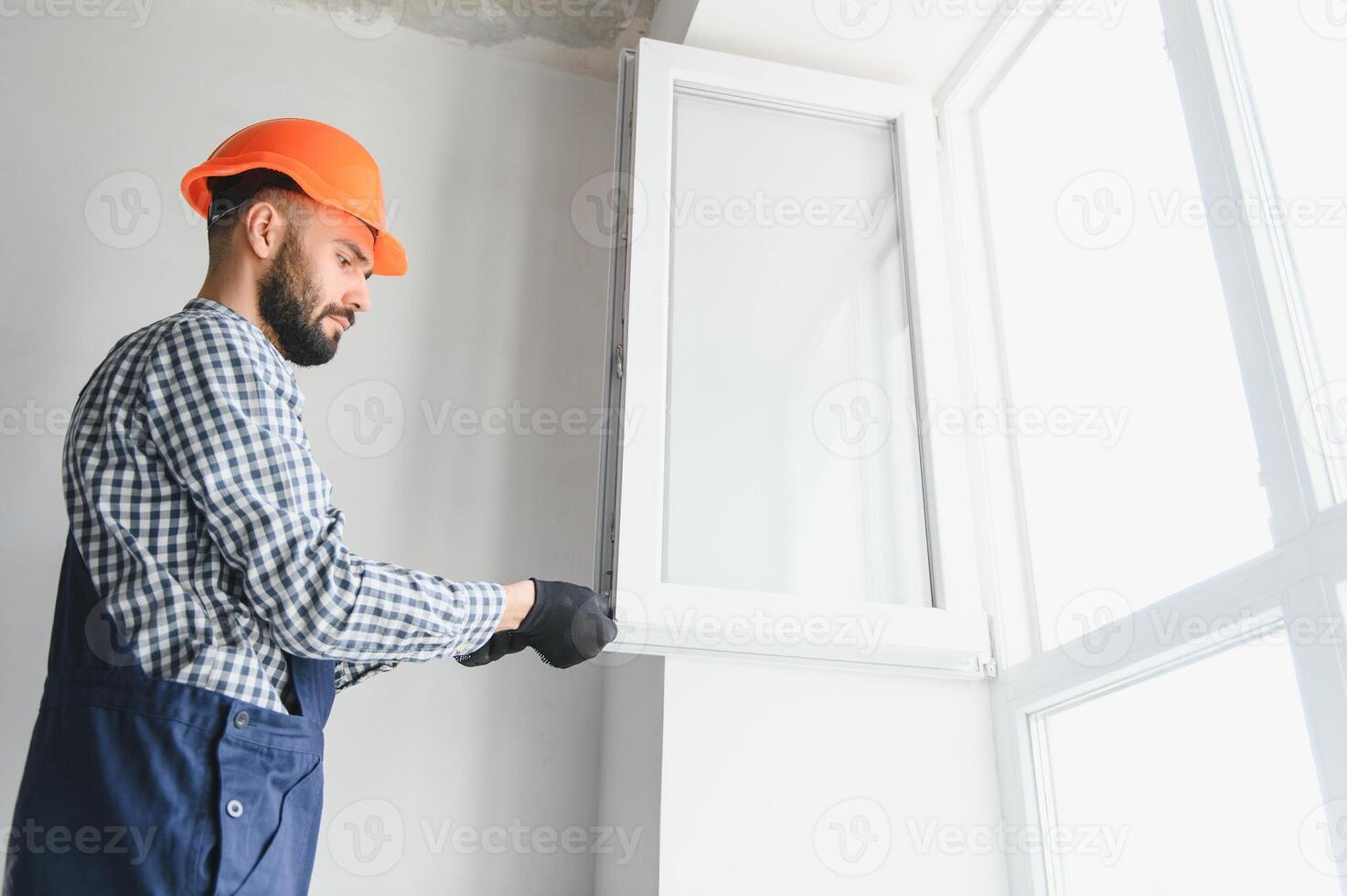Worker installing plastic window indoors photo