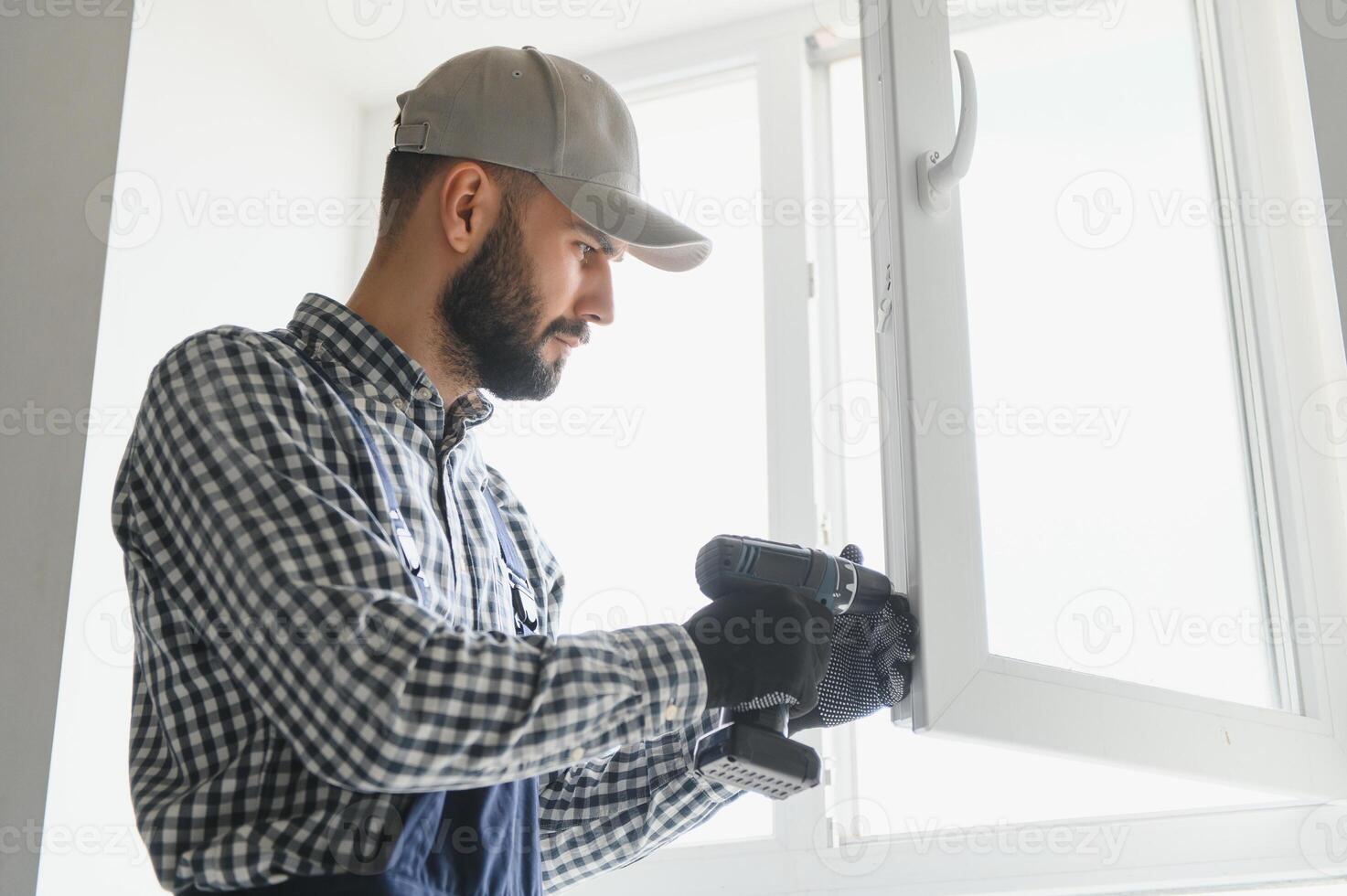 Worker installing plastic window indoors photo