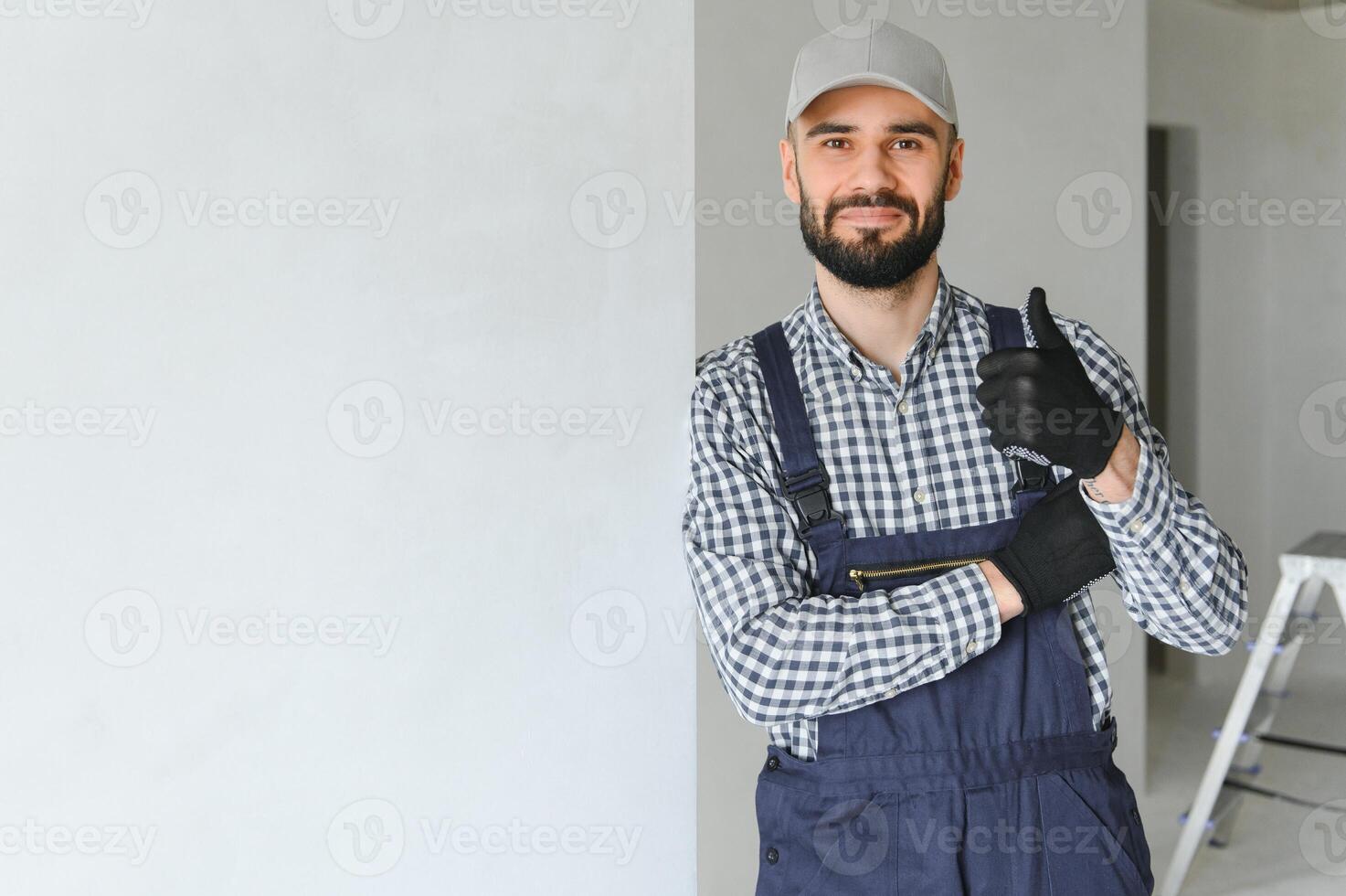 smiling repairman standing near stepladder and looking at camera photo