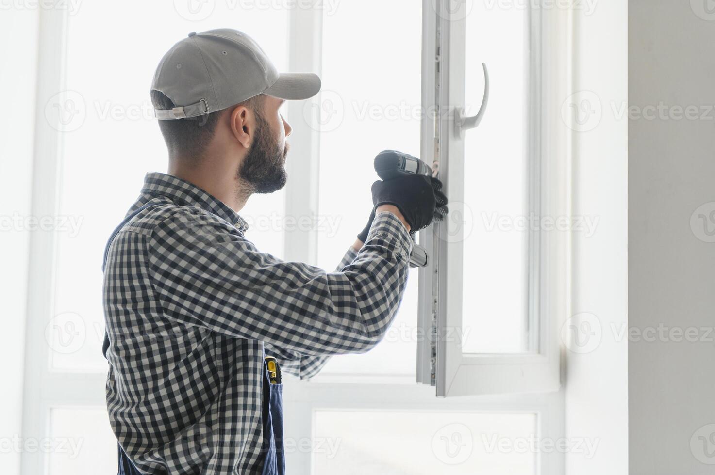 service man installing window with screwdriver photo