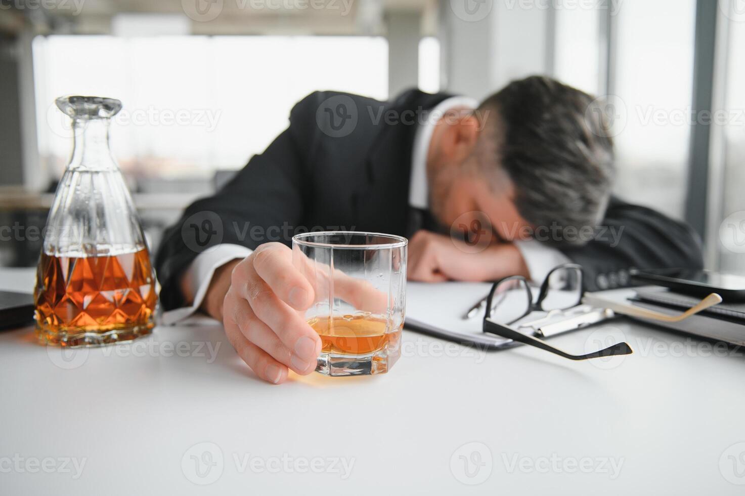 Alcoholism at work. Tired employee drinking alcohol at workplace, can not handle stress photo