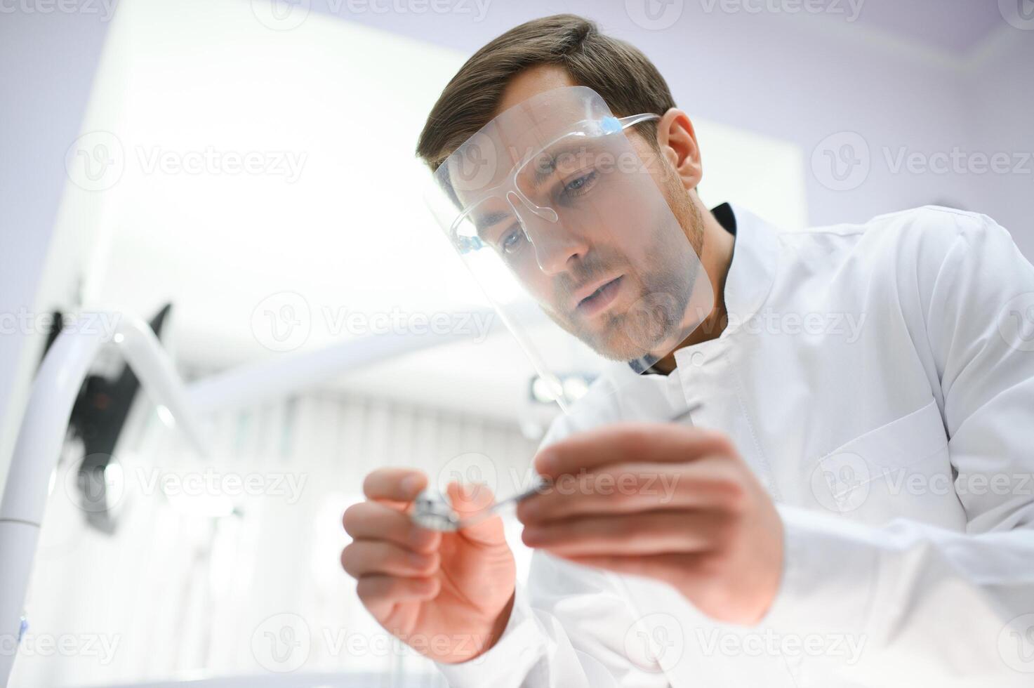 Bottom view. Dentist man with a tool in his hand. photo