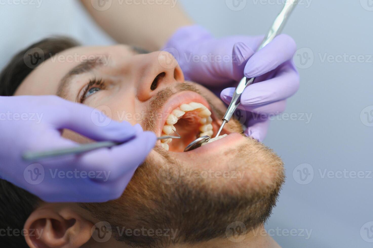 Young man at the dentist. Dental care, taking care of teeth. Picture with copy space for background. photo