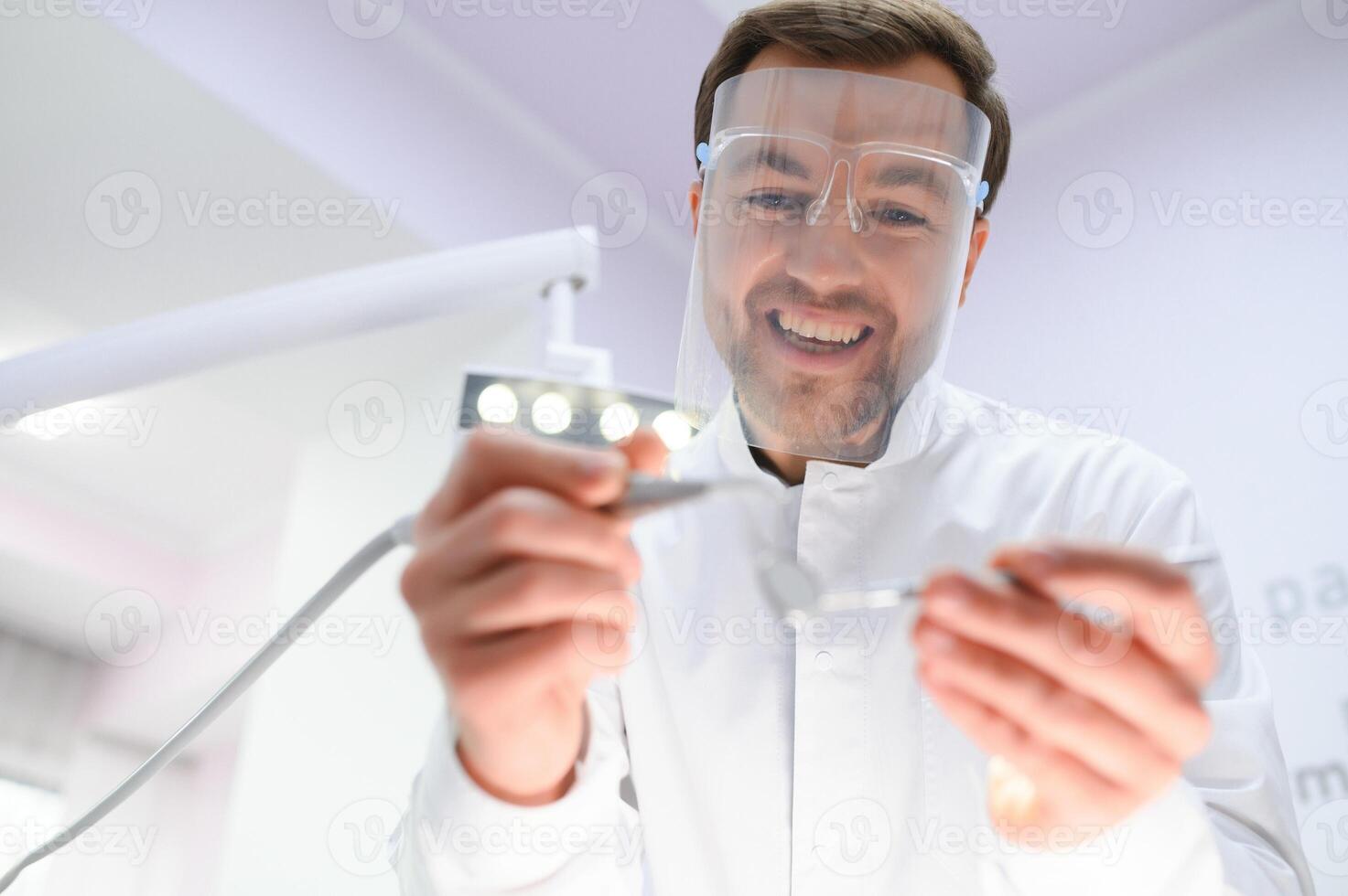 Bottom view. Dentist man with a tool in his hand. photo