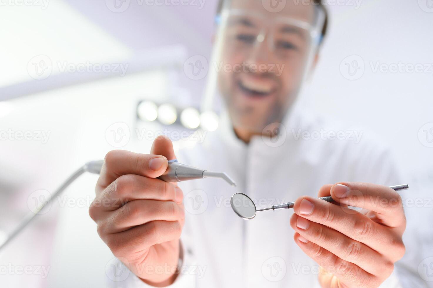 Bottom view. Dentist man with a tool in his hand. photo
