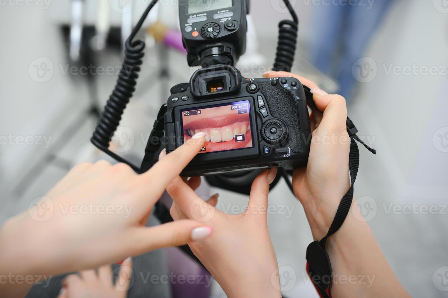 Female dentist photographs her patient's teeth in a dental chair. photo